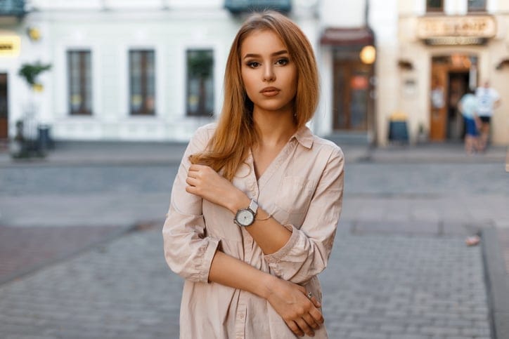 Stylish beautiful woman posing on a background of a building