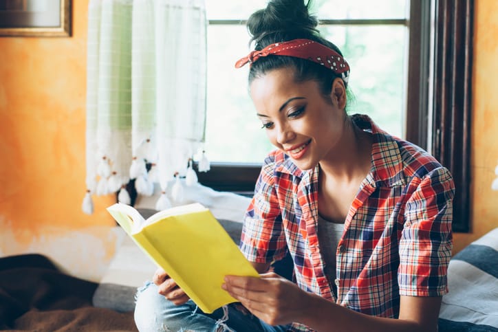 young woman reading solo apartment