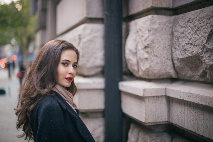 Stunning beautiful woman with red lipstick out in the city, on a lovely day.