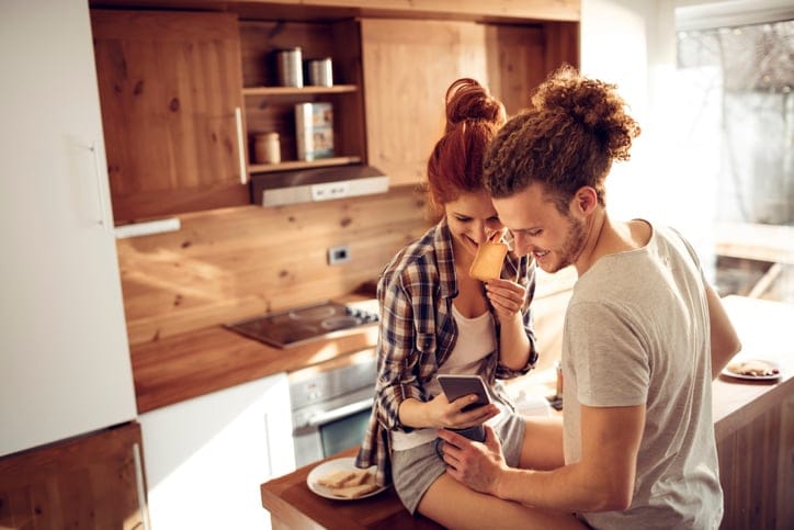 Close up of a happy young couple using a phone