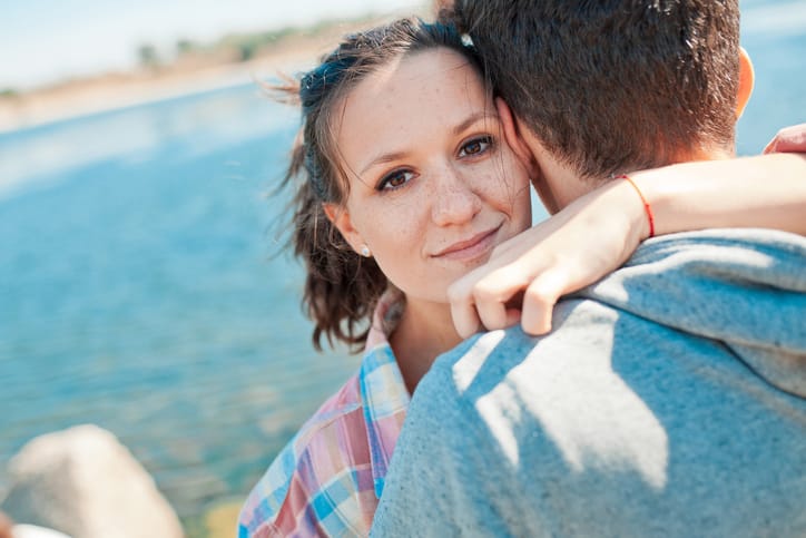 Teenage girl hugging young man