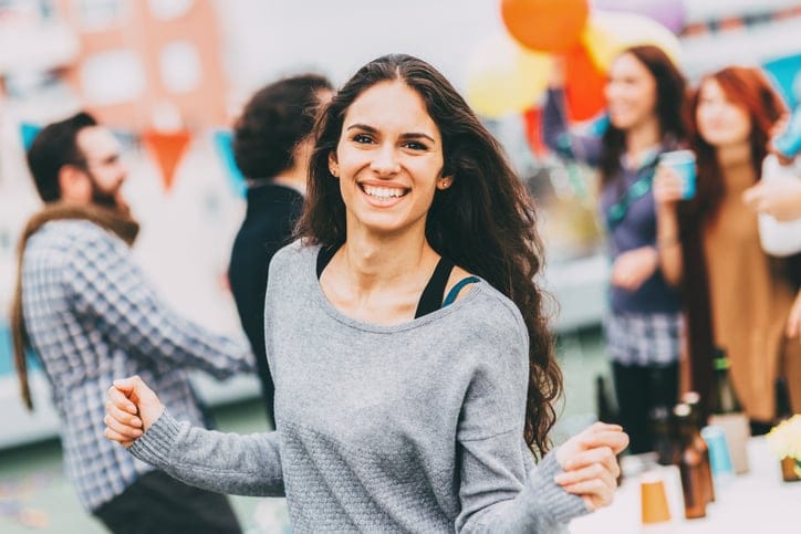 Portrait of a girl dancing at a roof party.