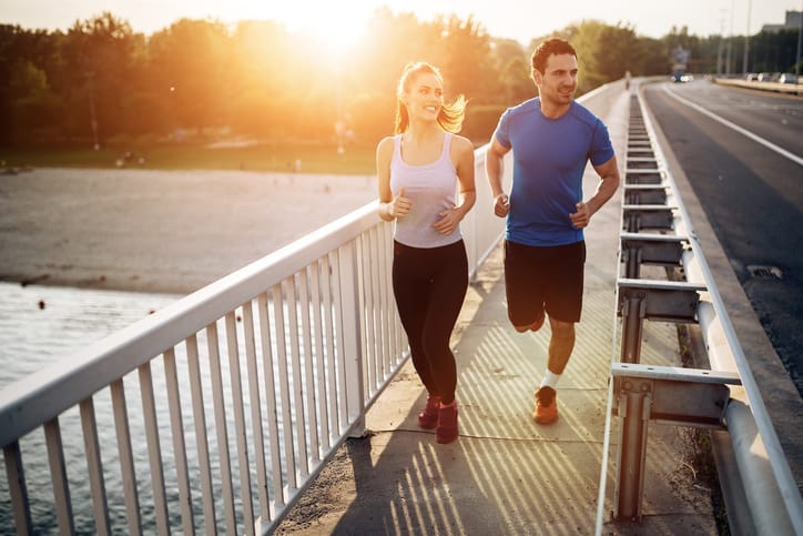 Active couple jogging outdoors during sunset