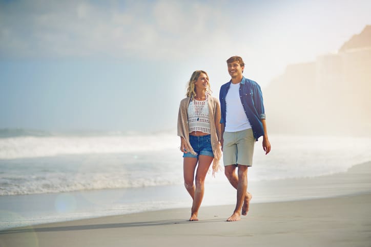 Full length shot of a young couple walking on the beach