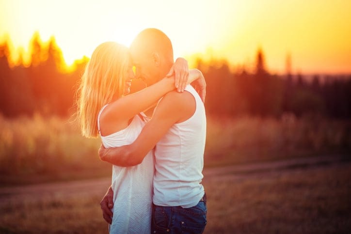 Couple in field at sunset
