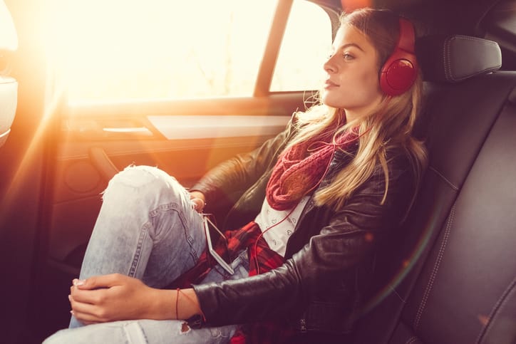 Woman travelling, wearing headphones.