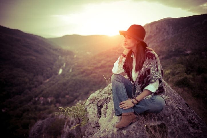 Woman sitting and relaxing on top of the mountain