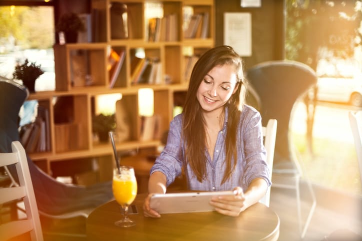 Young woman working on her tablet in a coffee shop
