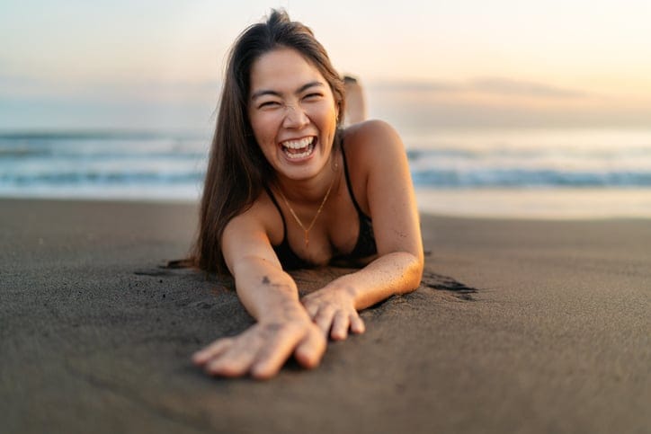 Woman in bikini on sandy beach.
