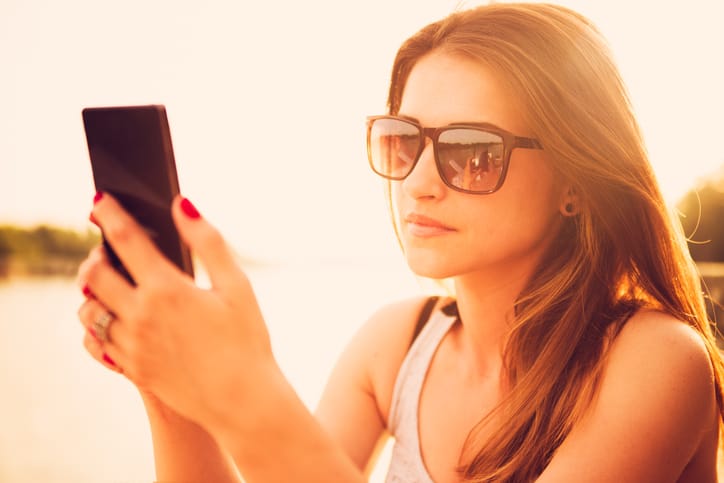 Beautiful woman with sunglasses using smart phone. Outdoor