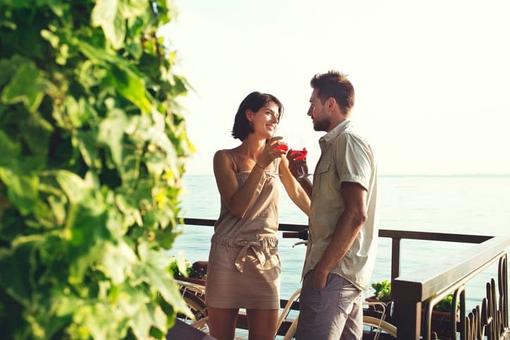 couple in love having spritz time with lake view in summer