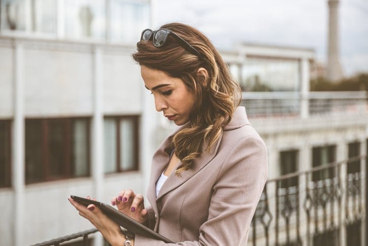 Businnesswoman at the cafè, using tablet and writing notes.