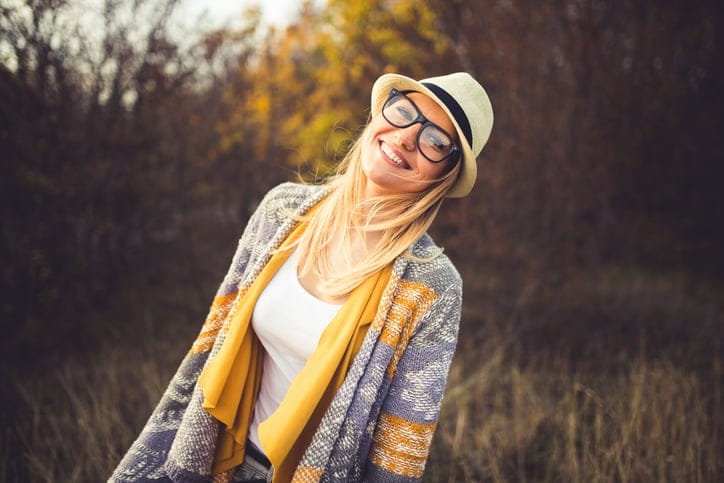 Fashionable young girl standing in the field and posing