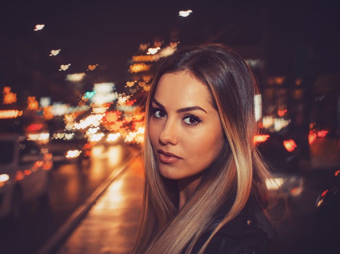 Girl walking in city at night.