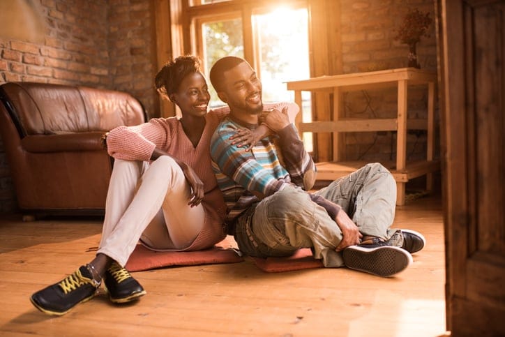 Young happy African American couple relaxing embraced at their home.