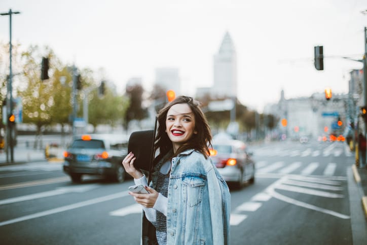 Stunning beautiful woman with red lipstick out in the city, on a lovely day.