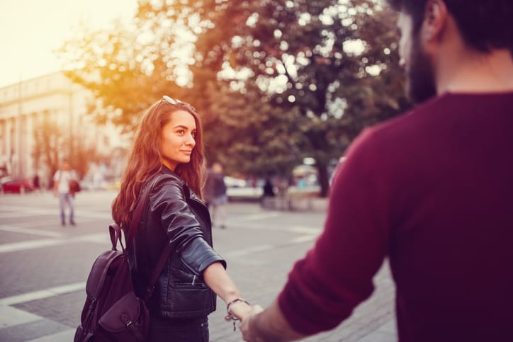 Young couple holding hands at the street