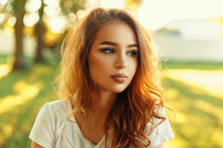Beautiful woman's face on a summer day in the park.