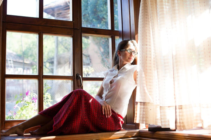 Beautiful young woman sitting and looking outdoors