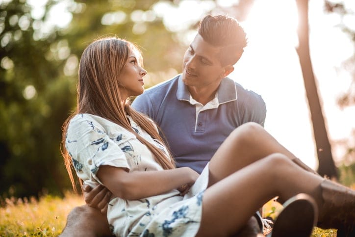 Loving couple relaxing at the park and talking to each other.