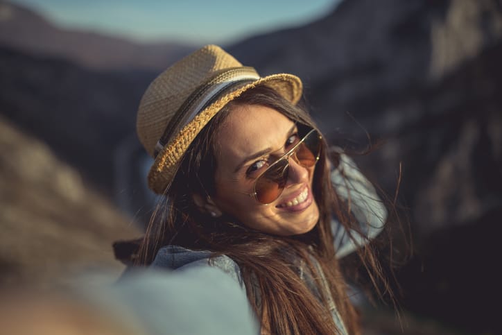 Young hipster girl taking selfie on the top of the mountain