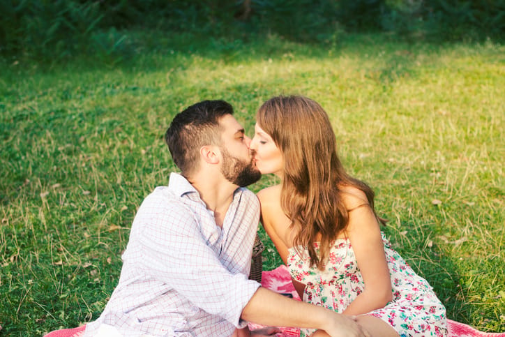Happy young couple kissing in park
