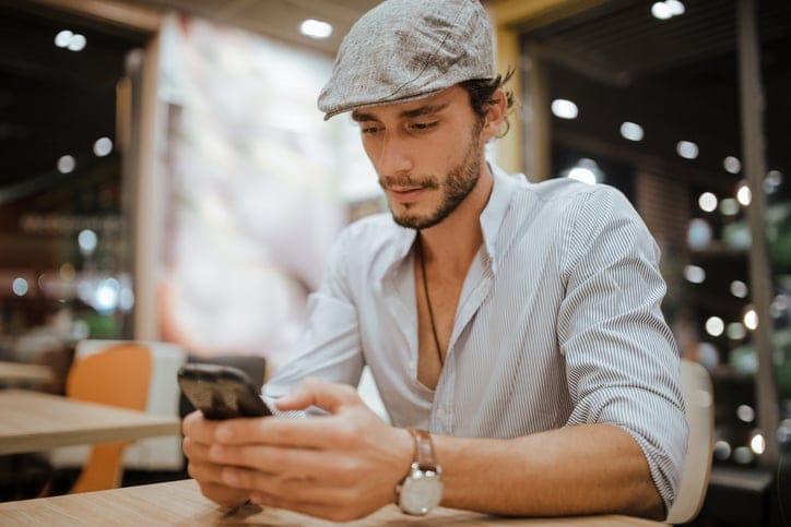Hipster texting on his mobile phone.