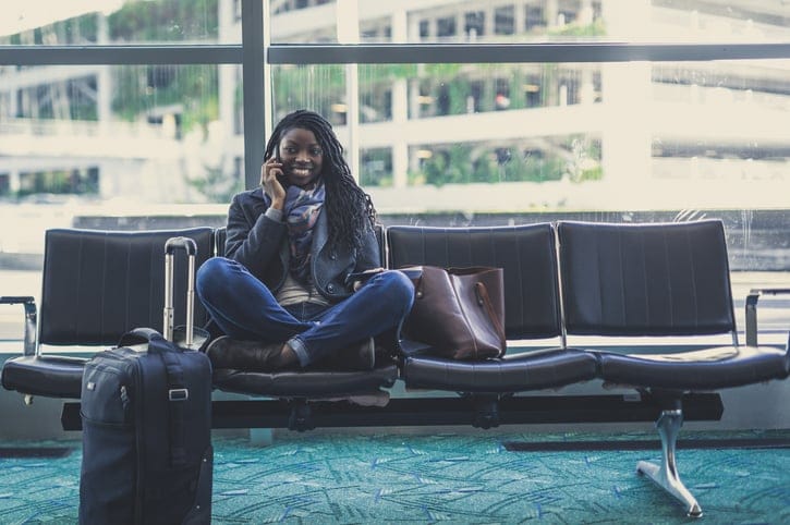 Woman sitting in an airport on her cell phone.
