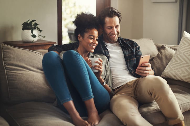 couple texting on couch