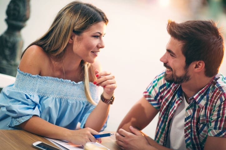 Young couple sitting in a cafe, talking and enjoying on the first date