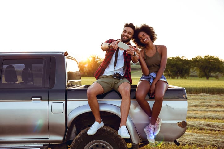 oung friends enjoying the freedom on a Car Trip over a country offroad