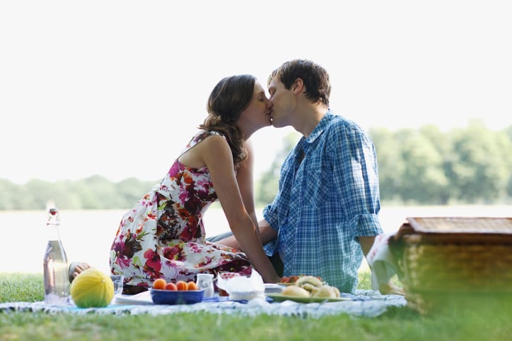 Couple having picnic in park and kissing