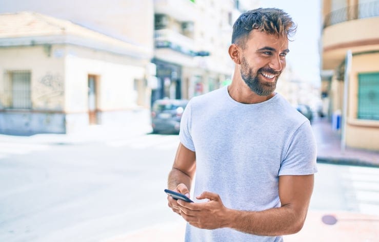 cute guy texting city street