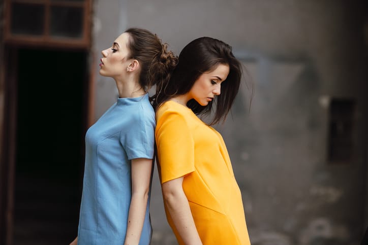 Two young beautiful girls posing against the backdrop of an abandoned building