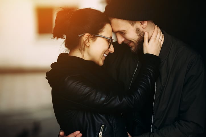 young beautiful couple posing in the side street at the camera