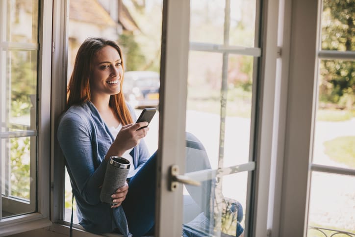 Enjoying the fresh country air with smart phone and coffee