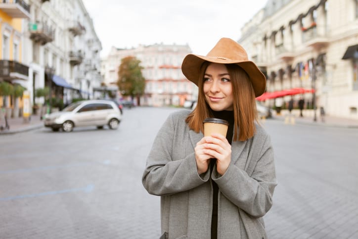 skeptical woman holding coffee city street