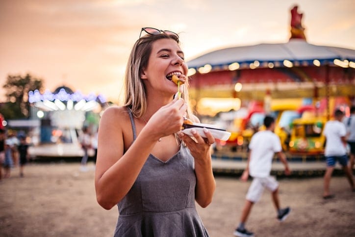 woman eating snacks at fair