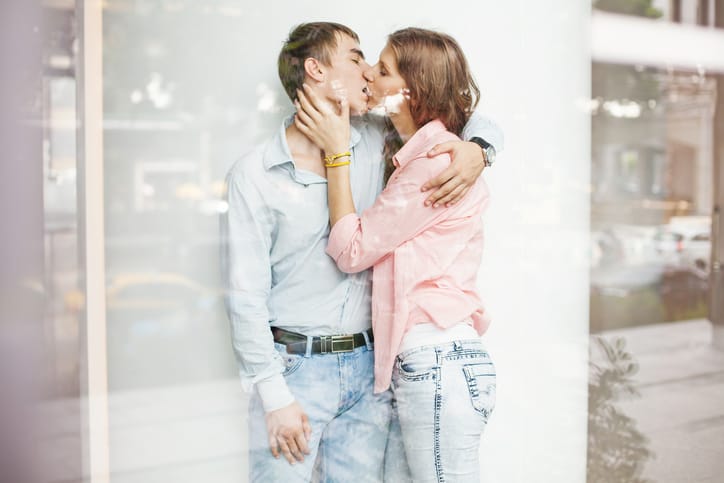 Two people kissing, view through the window