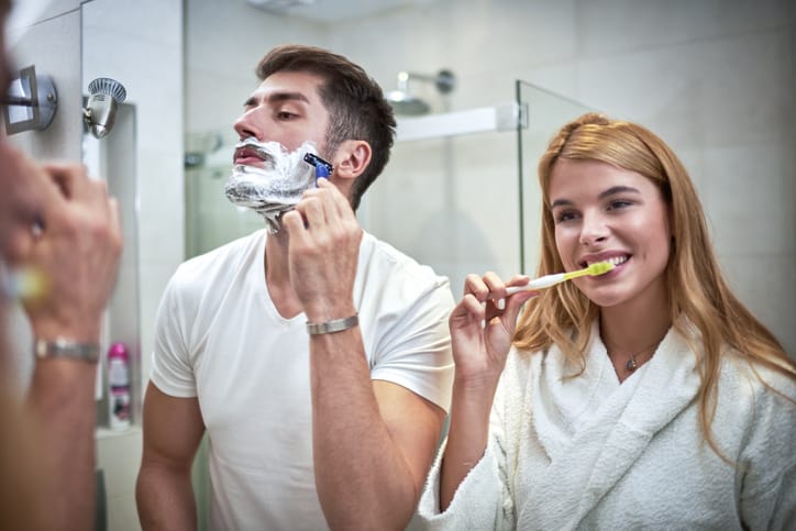 Couple at the bathroom sink.