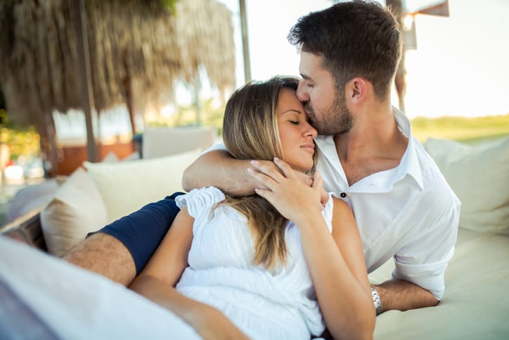 Photo of young couple in love lying on the beach