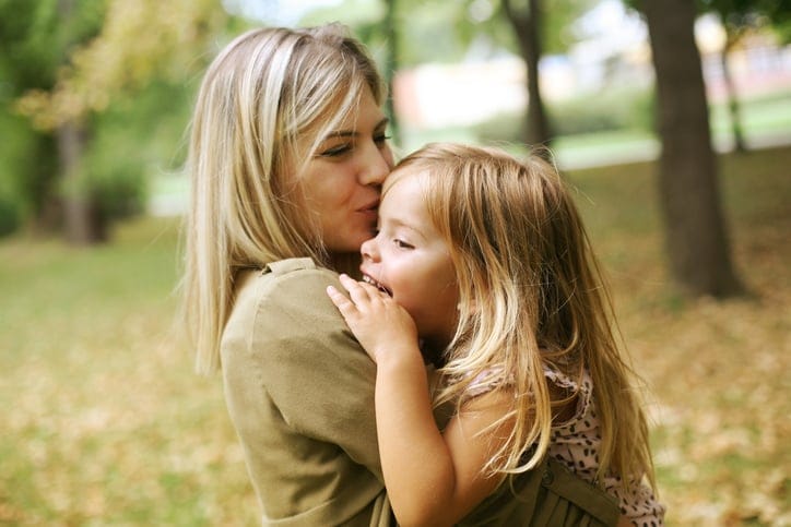 Mother with her daughter playing in the park.