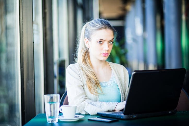 Woman working in a coffee shop on her laptop.