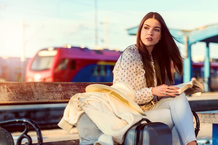Girl on train station with luggage.