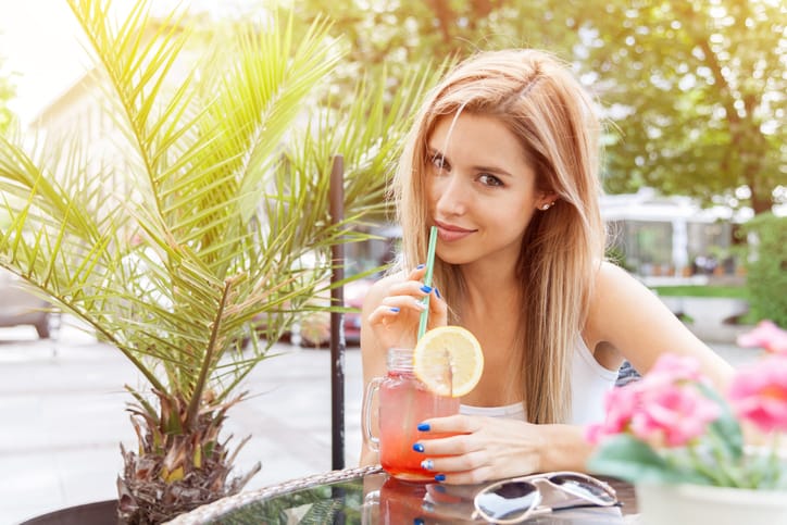 Young smiling girl drinking tasty cocktail , outdoor