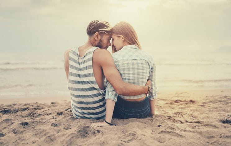 Happy couple date at the seaside at sunset