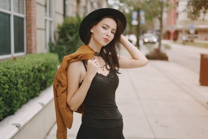 beautiful young model posing in hat on the street