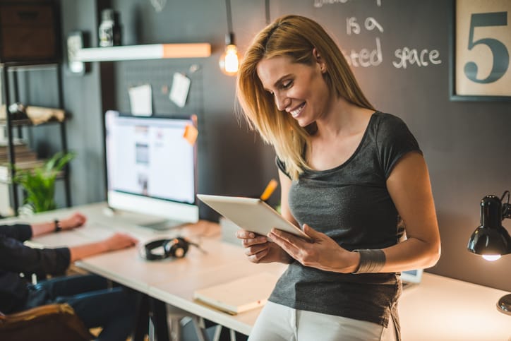 Businesswoman communicating with clients on a tablet.