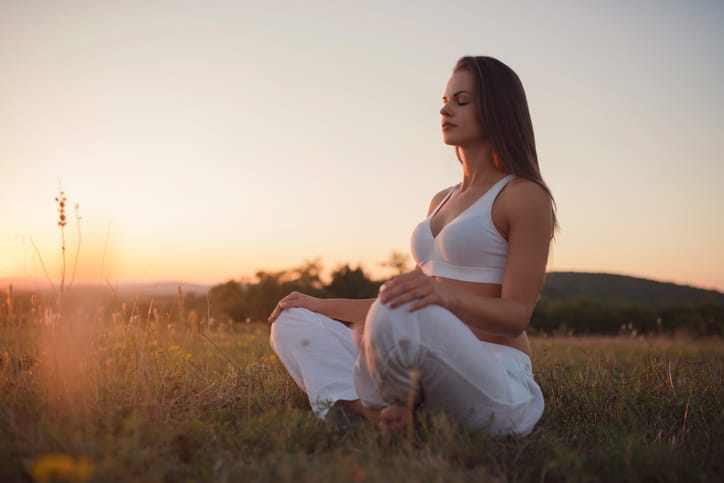 beautiful woman doing yoga sunset