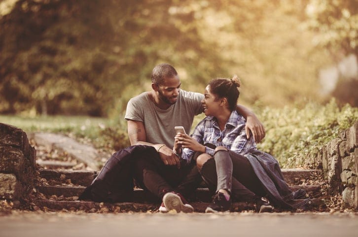 Embraced African American couple communicating in the park.